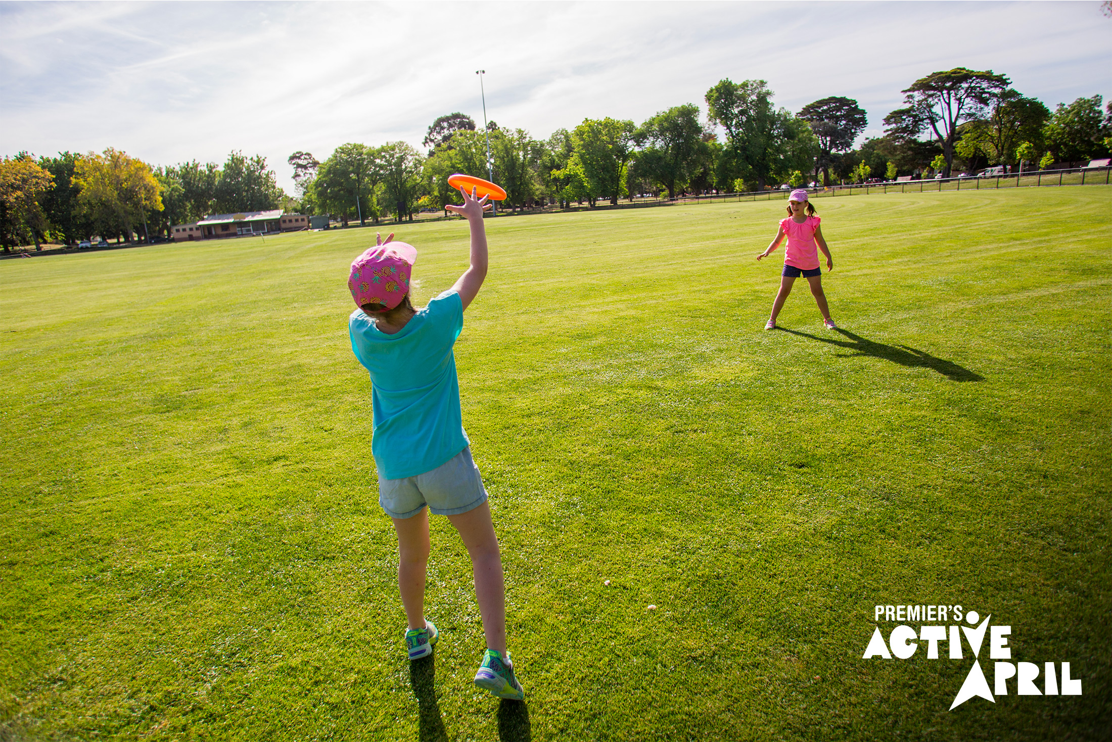 A boy and a girl throw the Frisbee outside