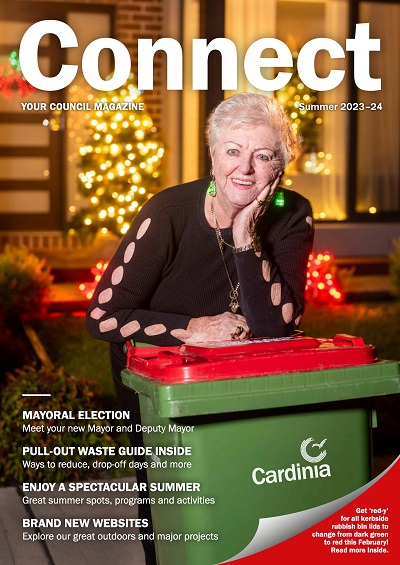 A local woman puts out her red-lidded bin, with her home's matching Christmas lights decorations in the background.