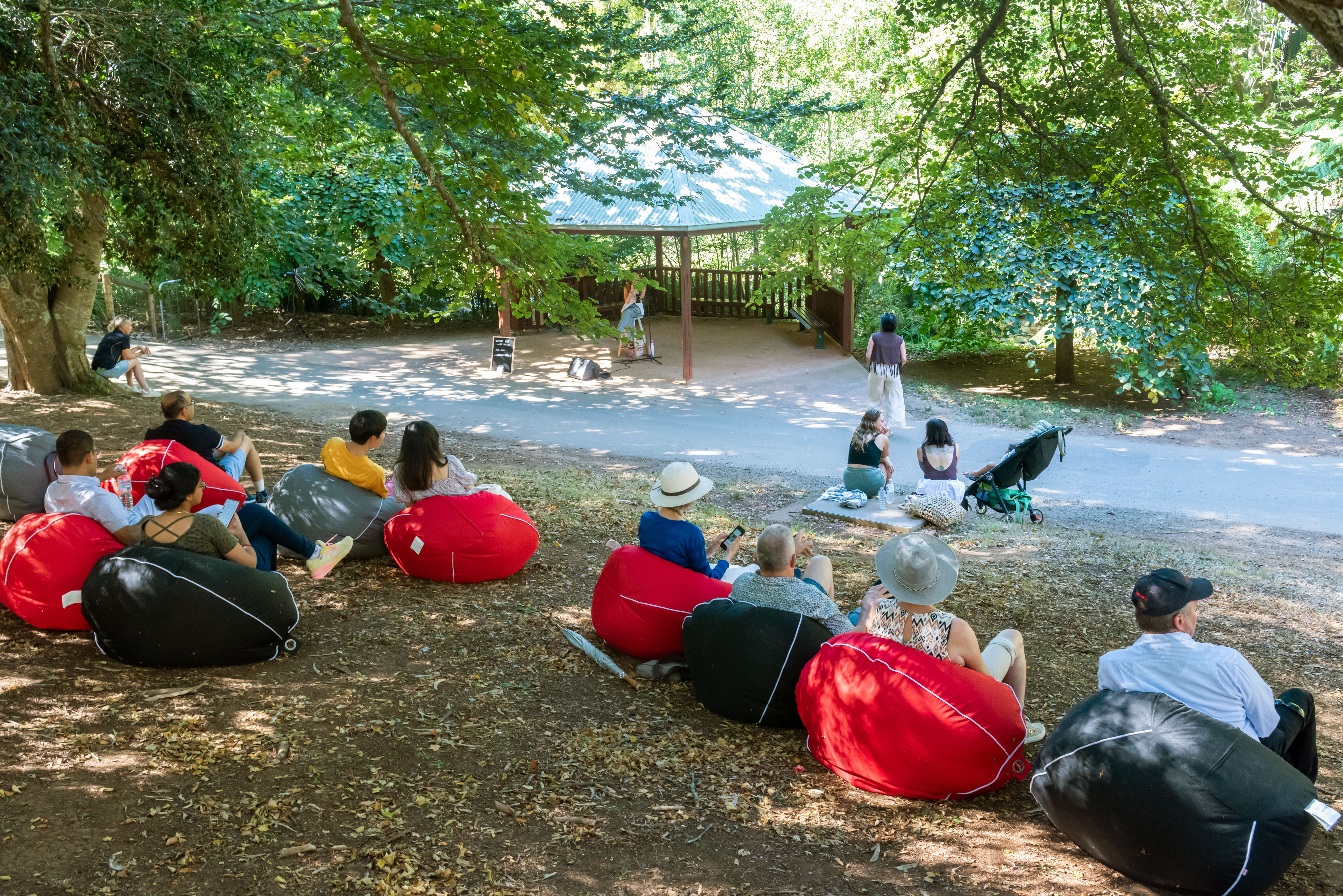 People sitting in the park on bean bags listening to music