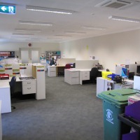 Large room with scattered desks and office equipment