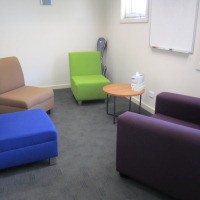 A small room with four arm chairs and small coffee table