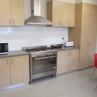 Kitchen with oven and rangehood with cupboards on both sides and over benches